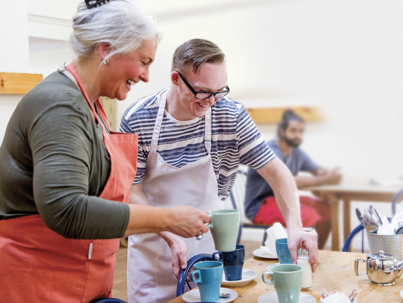 A man and woman prepare hot drinks in the local farm cafe.